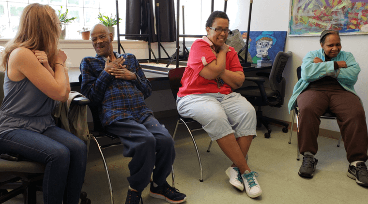 Engaging with aging group photo of participants sitting with arms crossed