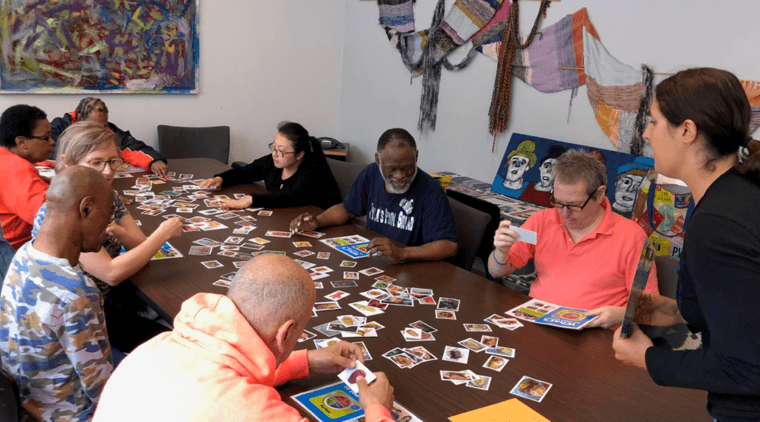 Engaging with aging group photo of participants sitting at a table working on their "life line" project