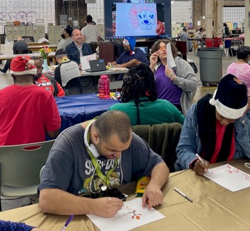 Westtown members work on their cartoons as Mark Daniels looks on.