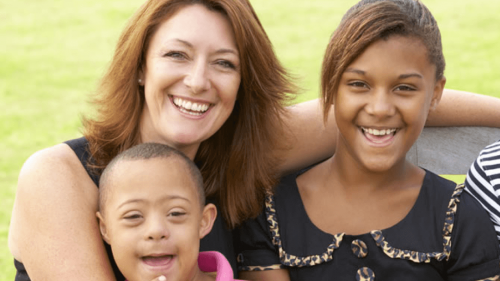 outdoors racial diverse family photo with two parents and three young children all smiling