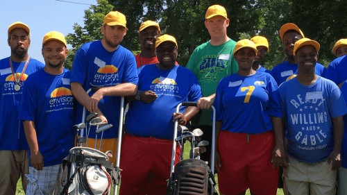 Team photo with each player wearing a bright yellow had and royal blue t-shirt
