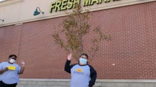 Members standing in front of grocery store