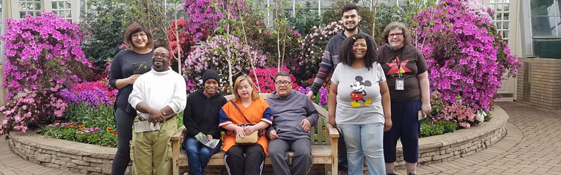 Group photo in front of bushes with violet flowers