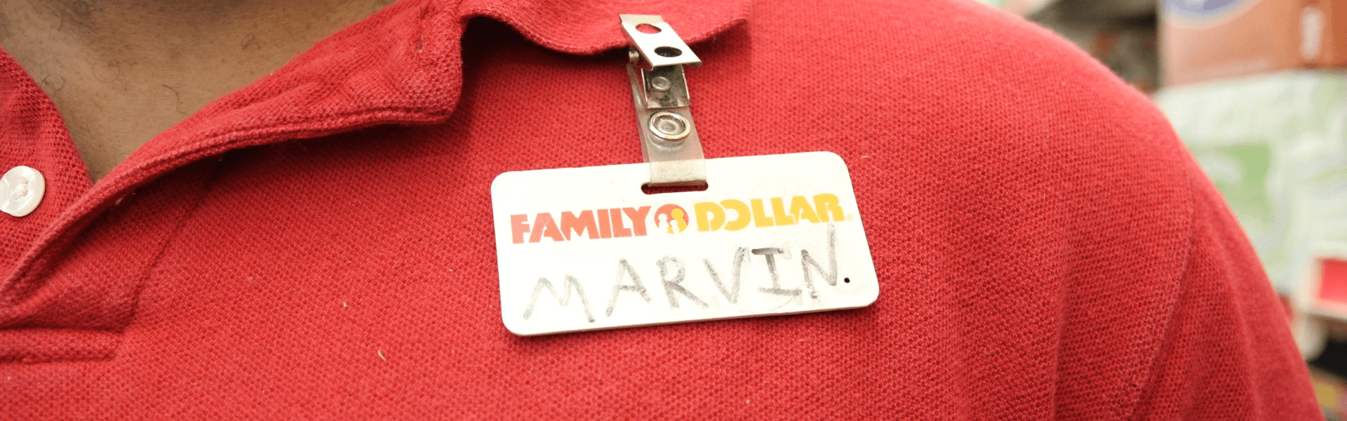 Close up photo to a red polo shirt and employee "Family Dollar" badge that reads "Marvin"