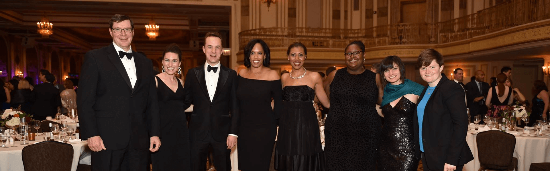 Group of people dressed in black and white suits and dresses at an Envision event