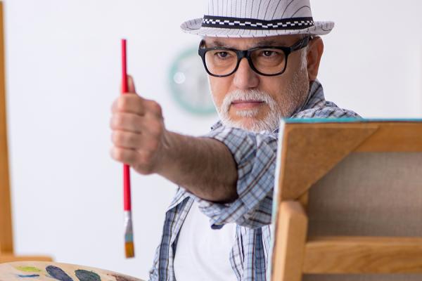 Older man painting a portrait
