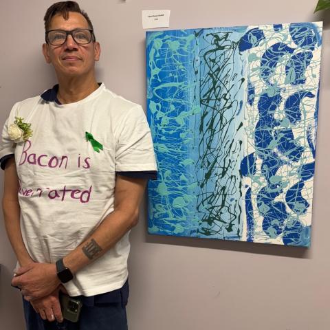 A person standing next to a painting.