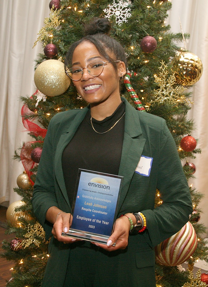 Leah Johnson hold plaque for being awarded 2023 Employee of the Year by Envision Unlimited.