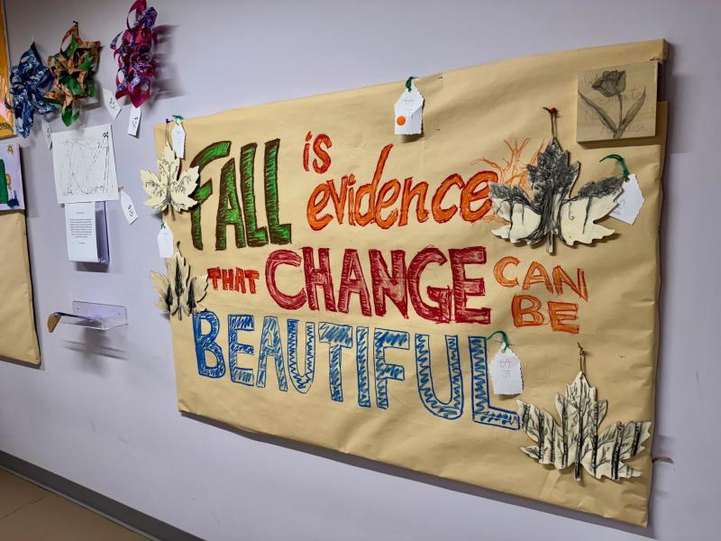 An art project on a light yellow background features hand-drawn text reading 'Fall is evidence change can be beautiful' in green, orange, red, and blue, surrounded by cutout leaves. Other art projects are visible in the left corner.