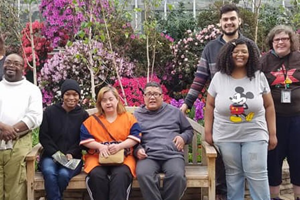 Group photo in front of bushes with violet flowers