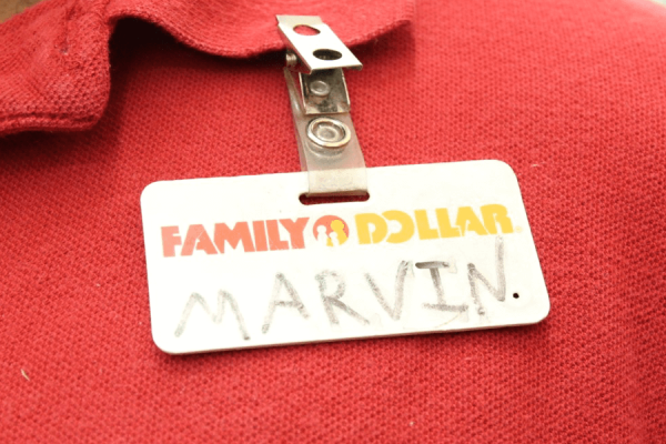 Close up photo to a red polo shirt and employee "Family Dollar" badge that reads "Marvin"