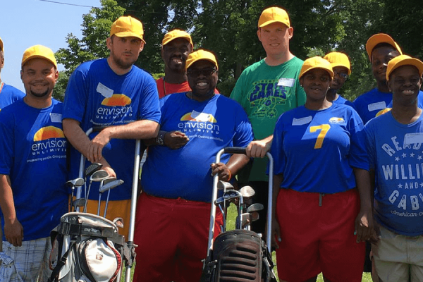 Team photo with each player wearing a bright yellow had and royal blue t-shirt